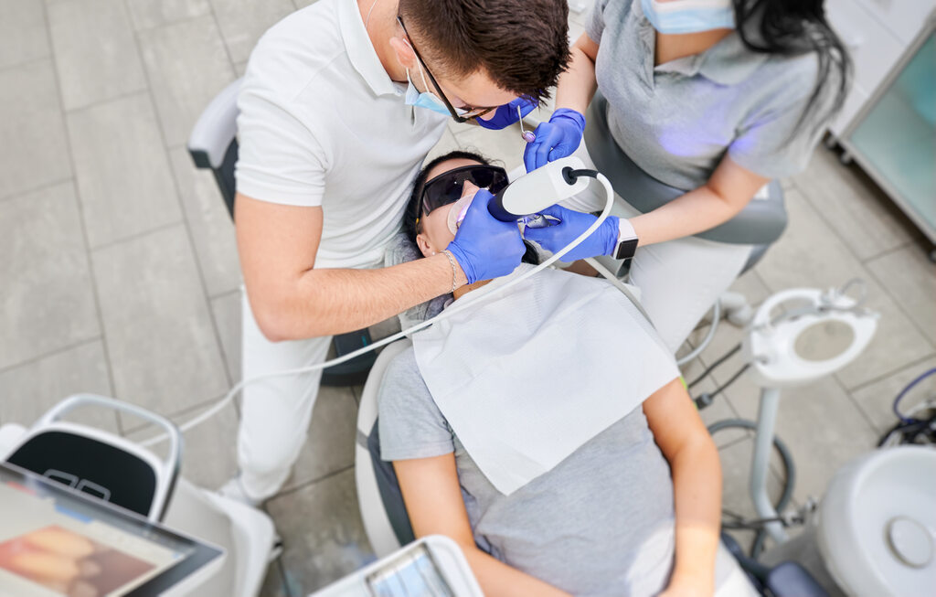 Dentista usando scanner odontológico para tratamento