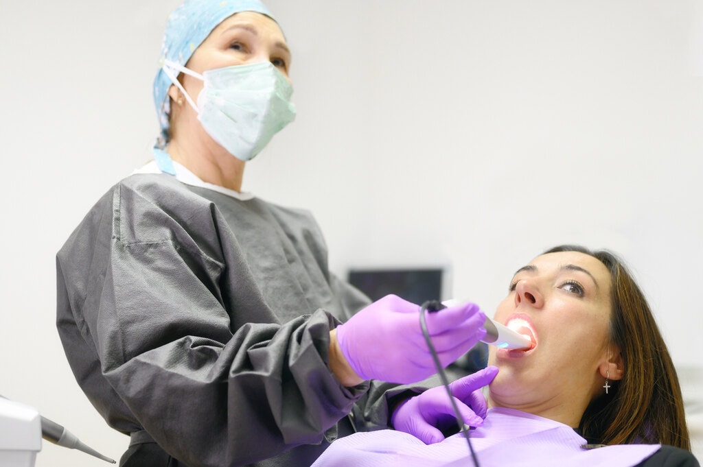  Paciente tendo os dentes examinados por uma câmera intraoral