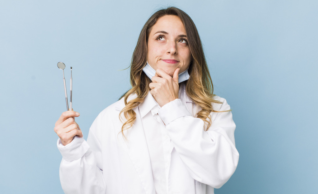 Dentista reflexiva ponderando sobre convênio odontológico